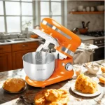 Batidora planetaria Finezza FZ-6812B de color naranja con tazón de acero inoxidable y tres accesorios de batido sobre un fondo blanco.