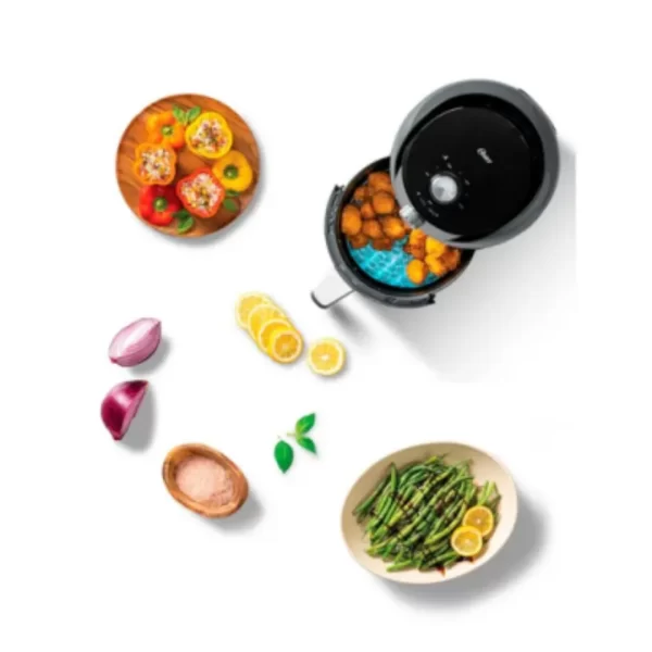 Freidora de aire Oster manual de 4 litros negra Diamond Force CKSTAF40MDF-053 con perillas de control de tiempo y temperatura sobre una encimera de cocina.